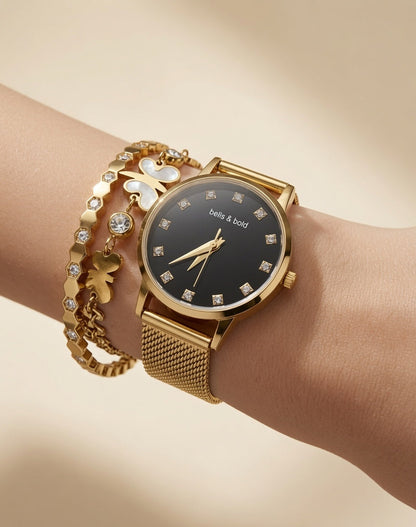 Gold watch with decorative bracelet on a wrist against a beige background